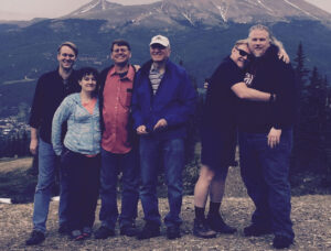 A group of men and women standing in the mountains.